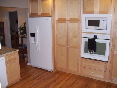 A different angle on the finished wall. There is a built in refer, pantry with roll out drawers, oven/microwave and another big pantry
