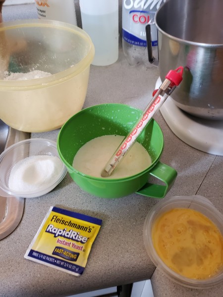 Got started by warming the milk. I use powdered milk.  I don't usually have milk in the house.  I used a candy thermometer to make sure it was between 110-115 degrees. I have killed yeast in the past.  I also made sure the butter and eggs were room temperature.  I need all the help I can get. I weighed out the 300 gms of all purpose flour.  The recipe called for bread flour, but I had to use up this flour first. It called for 1/2 tsp of salt and 38 g of sugar.  I stirred it together then combined it with the wet ingredients. I did forget to make the well, but that's o.k. the mixer handled that fine.