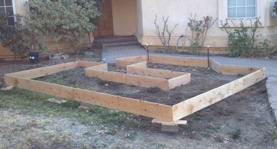 We used cedar fence boards and knew at the time that they wouldnâ€™t be a long term solution.  Our goal this coming winter is to build a stacked (no mortar) retaining wall around it, make it taller/deeper, and remove the cedar planks.  For the walkway inlet, weâ€™re thinking about using stacked 4x4s instead of stone.